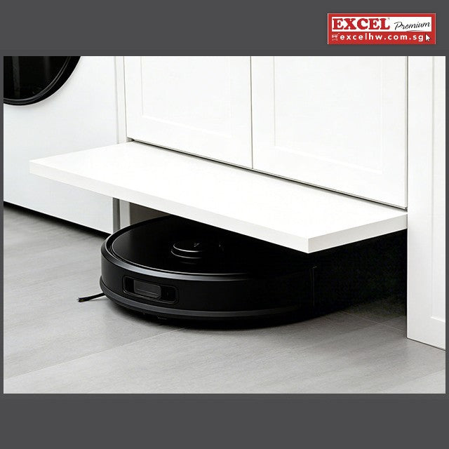 White cabinet kick panel flipped open as a black robot vacuum drives underneath